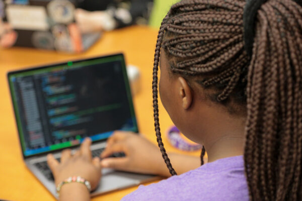 A female student works on coding projects with a WSU laptop.