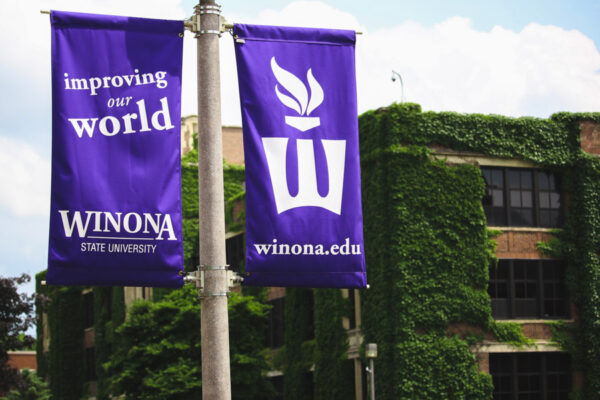 Purple banners with the WSU mission and Flaming W logo hang from campus light poles.