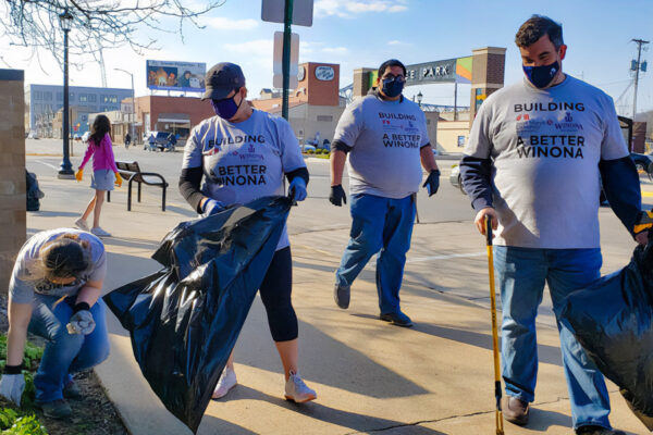 Alumni pick up trash during a volunteering event in downtown Winona.