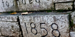 A stone wall with the words "Founded 1858" etched into the bricks.