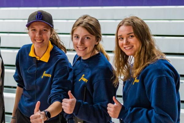 Three female students pose together while wearing their security office work uniforms.