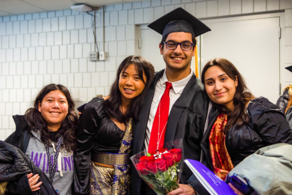A male graduate poses with friends and family after the WSU Commencement Ceremony.