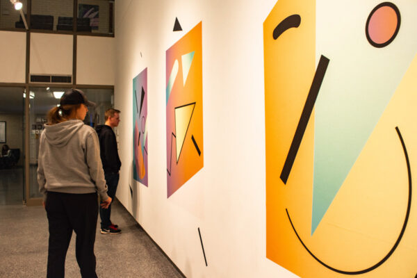 Students observe the art pieces at an art gallery on the WSU campus.