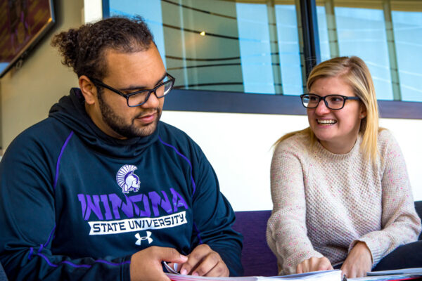 Two students work together in a lounge on campus.