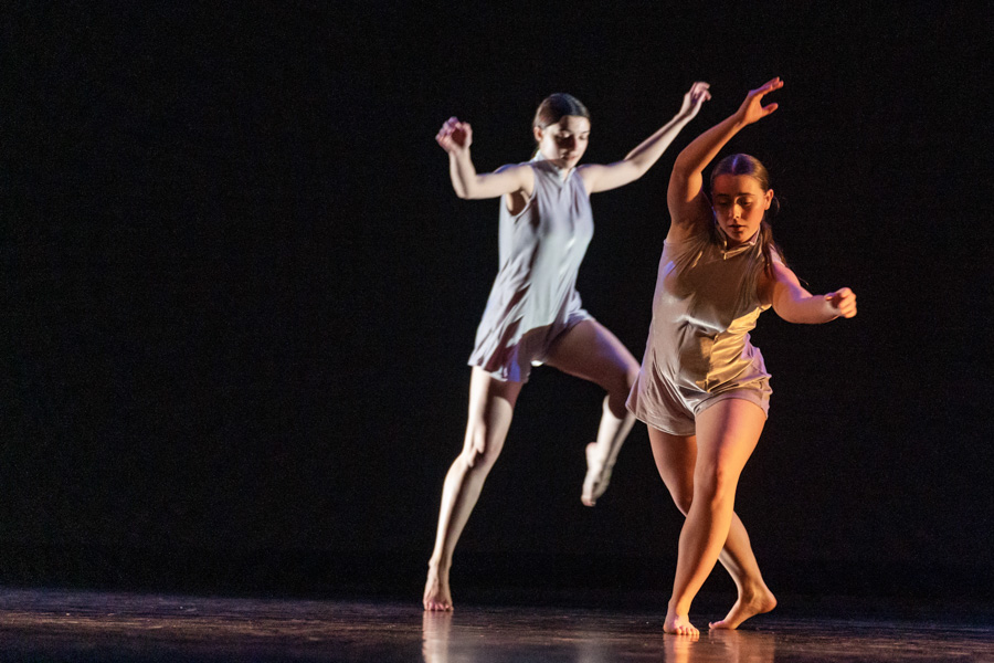 Two students dance on stage in a performance on the WSU campus