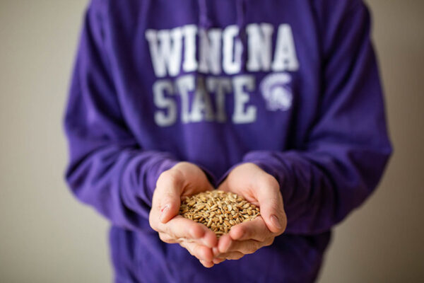 A student holds seeds in their hands.