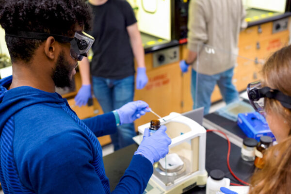 Two students work together with lab equipment during class.