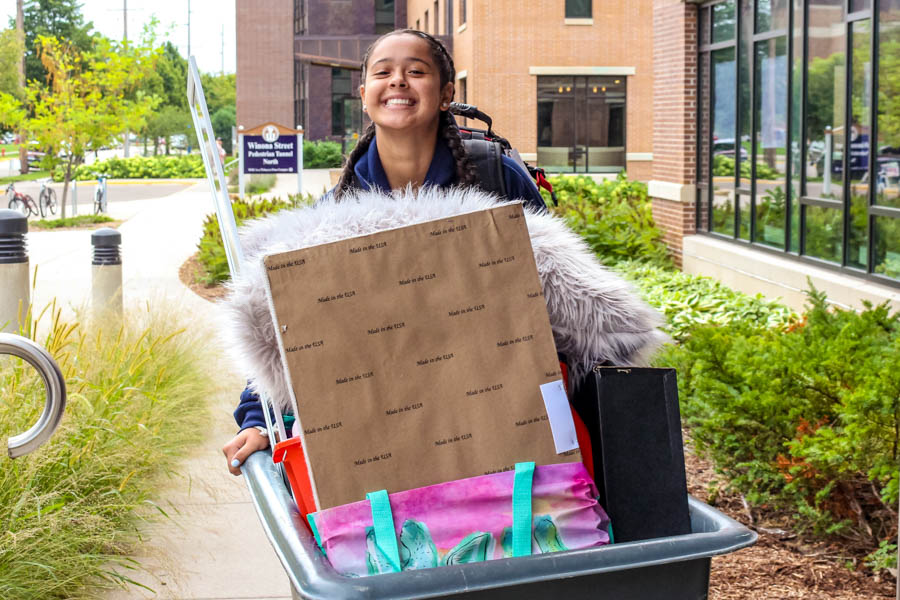 WSU student using a cart to move in to a residence hall.