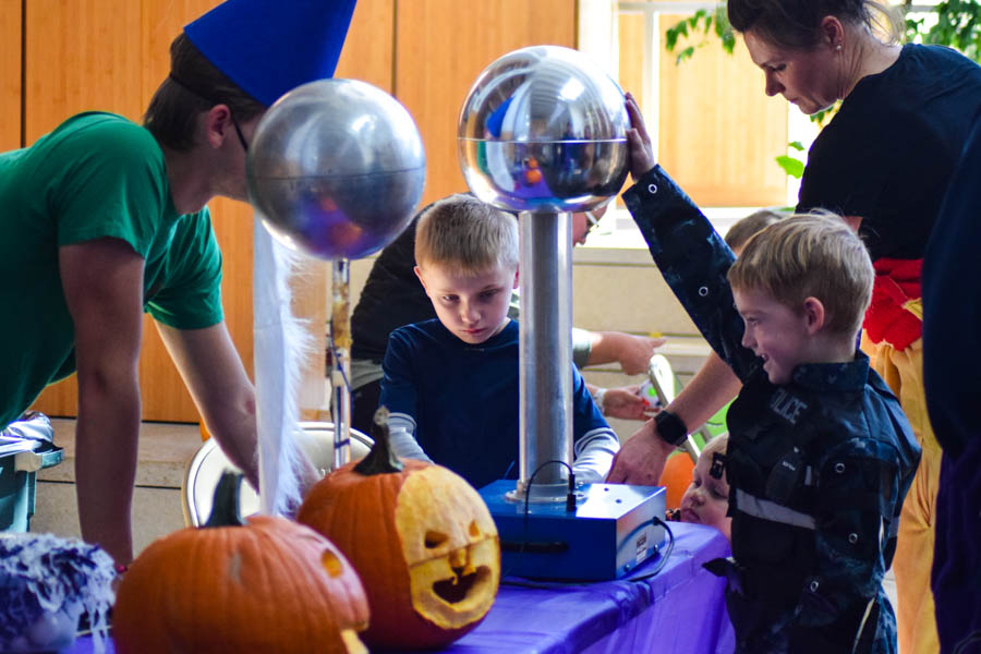 A child interacts with a science activity station at the STEM fair.