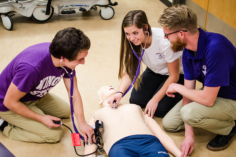 WSU students performing health care on a manikin.