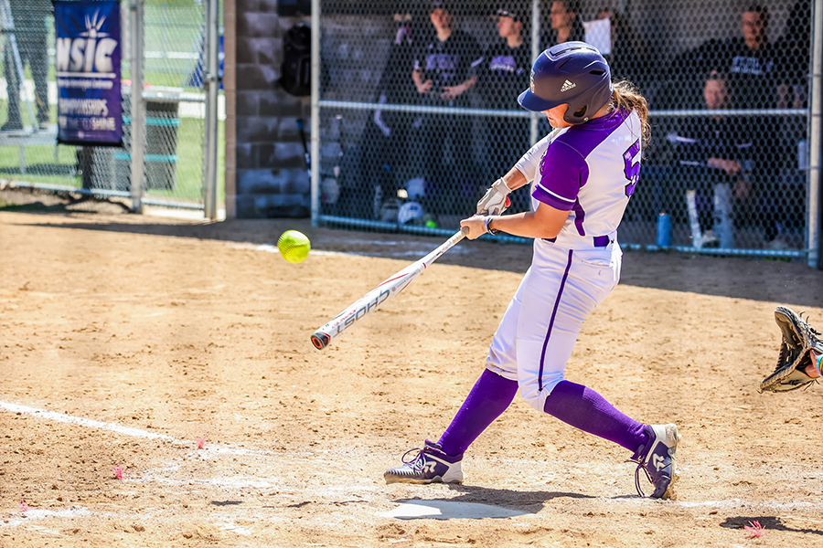 WSU women's softball athlete swinging a bat.