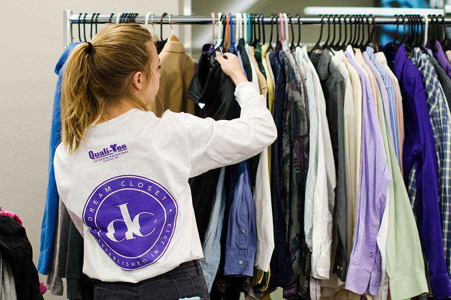 WSU student putting clothes on a rack