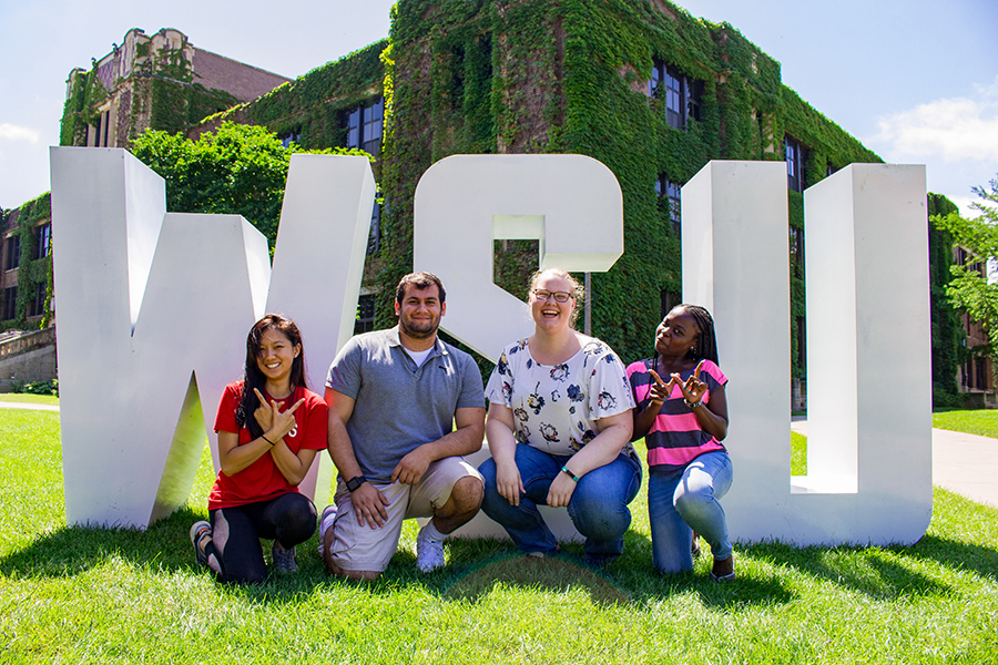 WSU students in front of WSU letters.