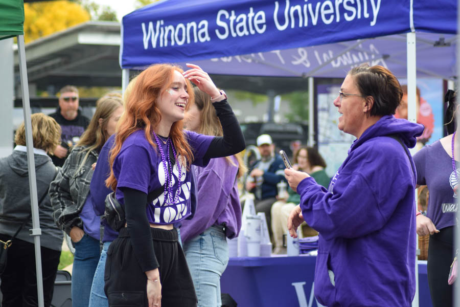 A WSU student talks to a community member by a Winona State University booth