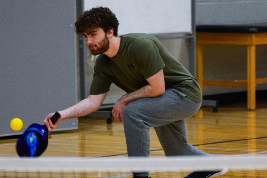 WSU student playing pickleball in a gym.