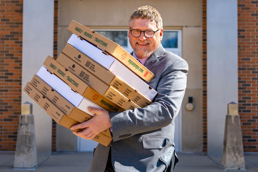 WSU President Kenneth Janz holding pizza boxes