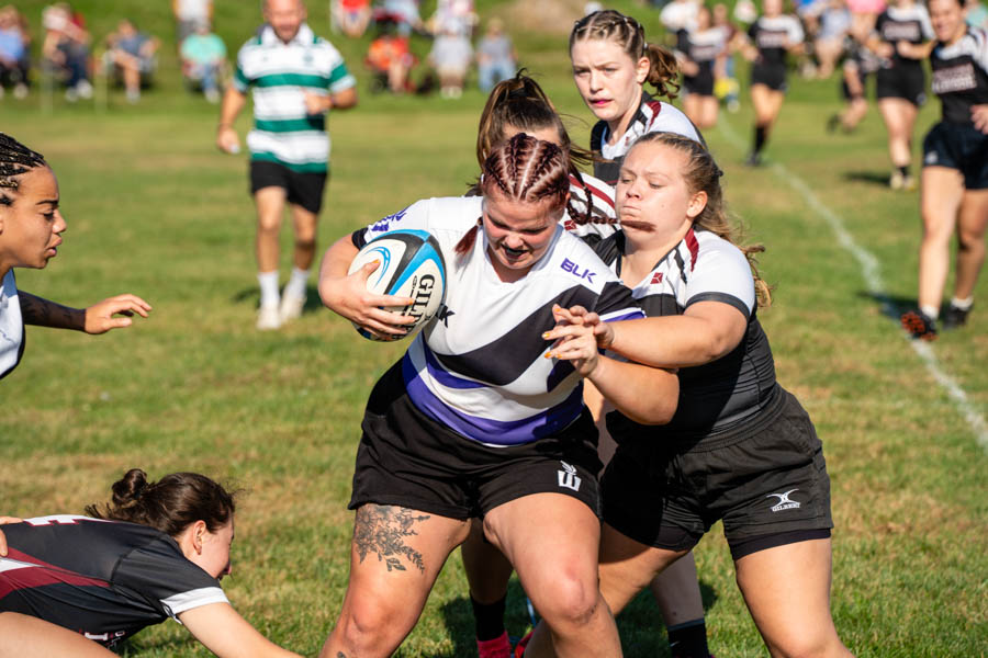 WSU women's Rugby team player holding a ball.