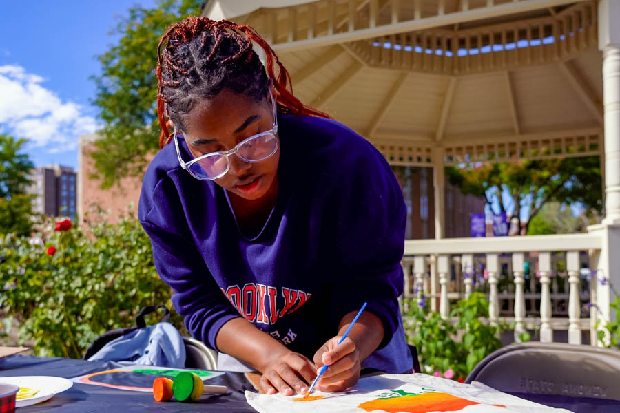 WSU student painting with a brush.