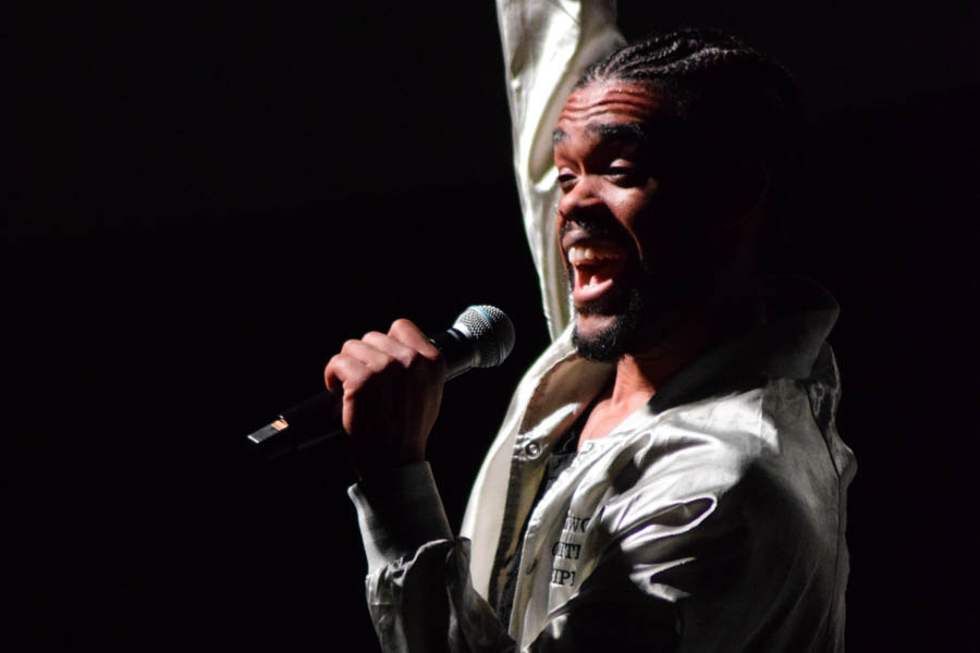 WSU student performing while holding a microphone.