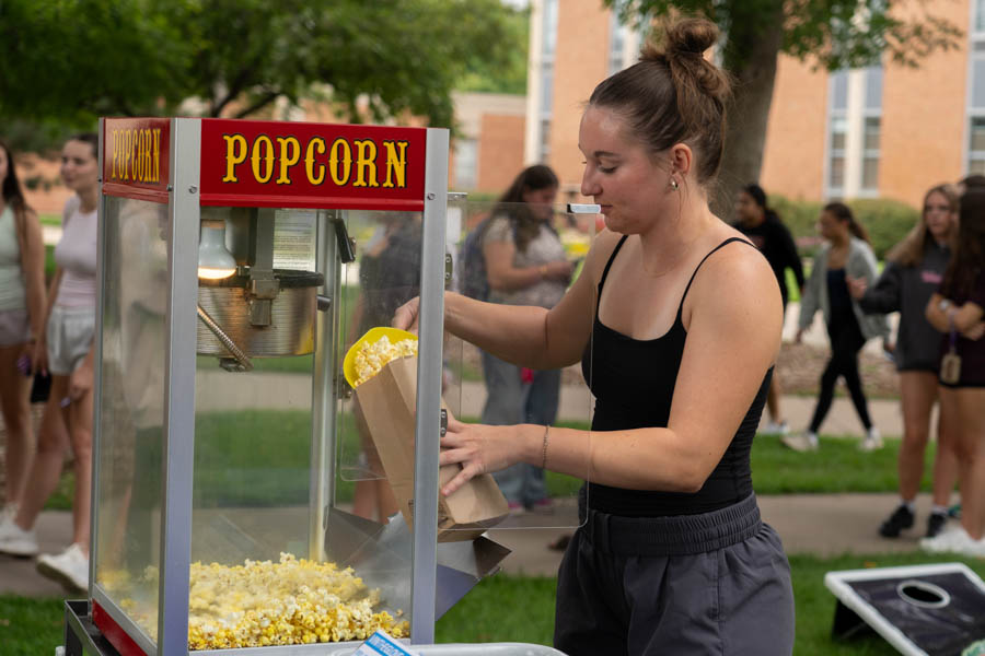 WSU student at a popcorn maker outside.