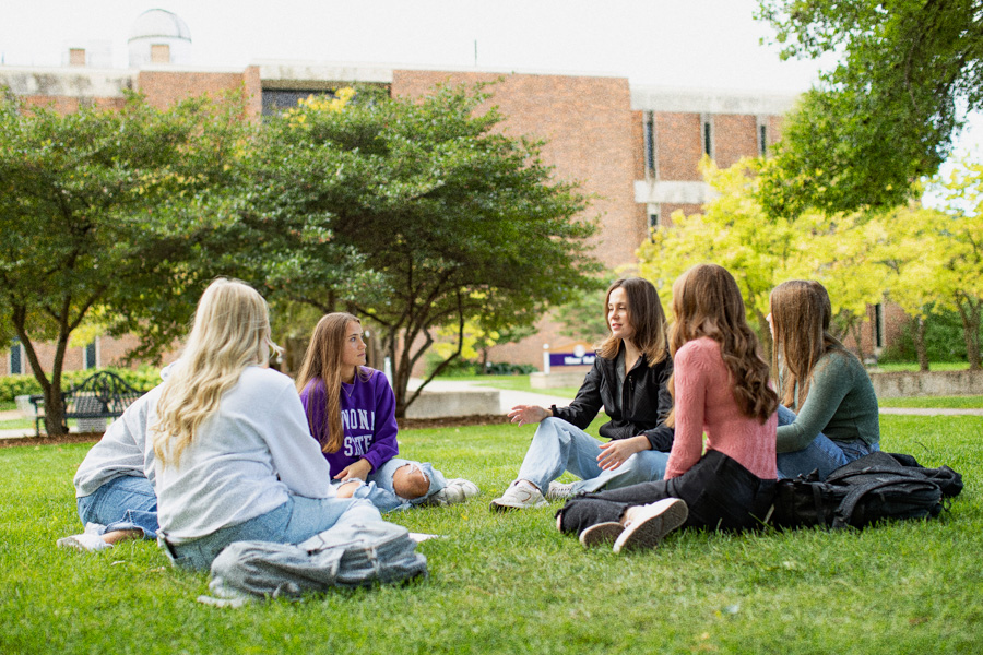 WSU students sitting on the grass on campus.
