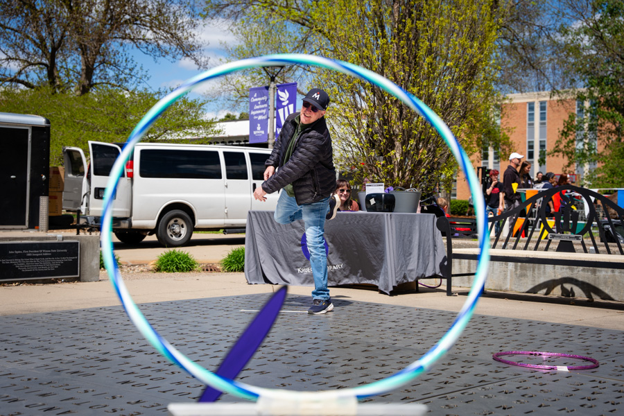 WSU guest throwing a disc through a hula hoop.
