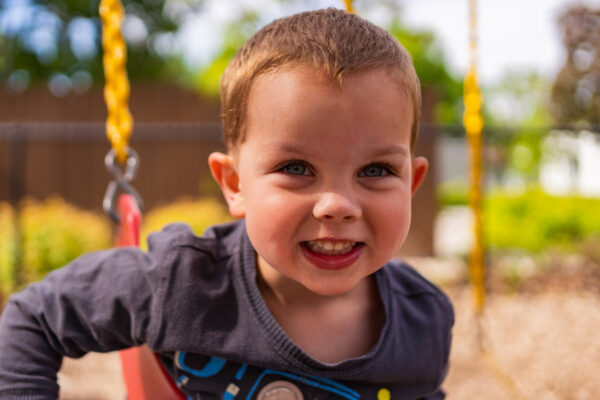 Children's Center young boy smiling on a swing