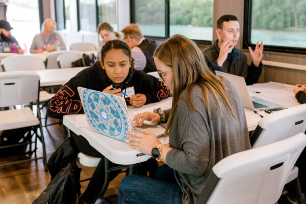 Students work together at tables during a class on the Cal Fremling boat.