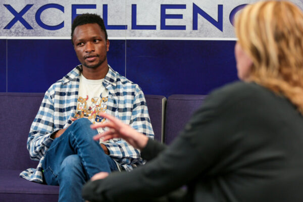 A male student listens to a guest speaker in the WSU Engagement Center.