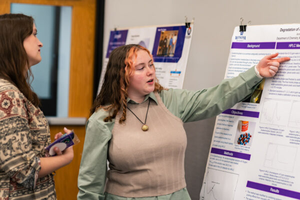 A female student presents a research project during the poster event.