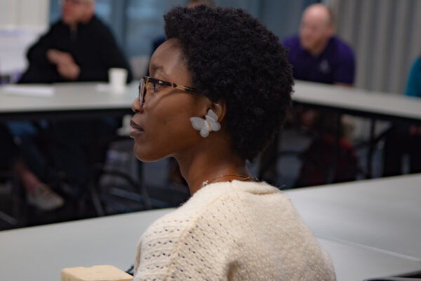 Student with butterfly earring listening to presentation