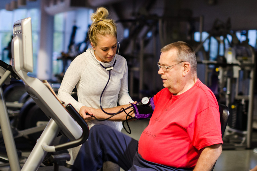 A WSU student works with an older adult during a rehab session.