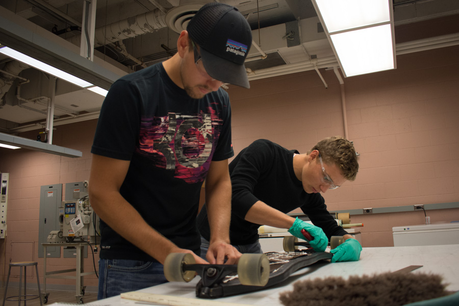 Two male students build a skateboard in the materials lab