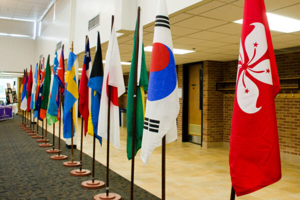 Flags from multiple countries are arranged in a line during an event on the Winona State campus.