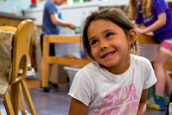 A young child smiles during class at a local elementary school.