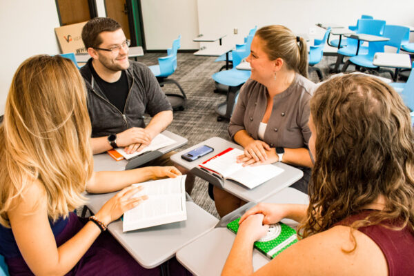 A group of students discuss a topic during class.