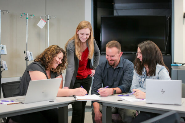 A group of students work together on a project in a nursing classroom at WSU.