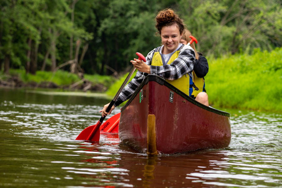 WSU students paddling in a canoe on the water.