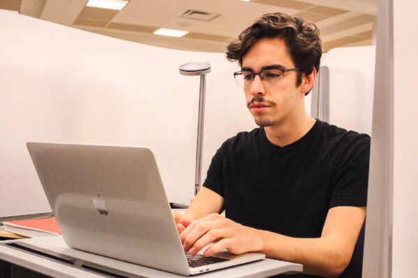 WSU student using a laptop in the library