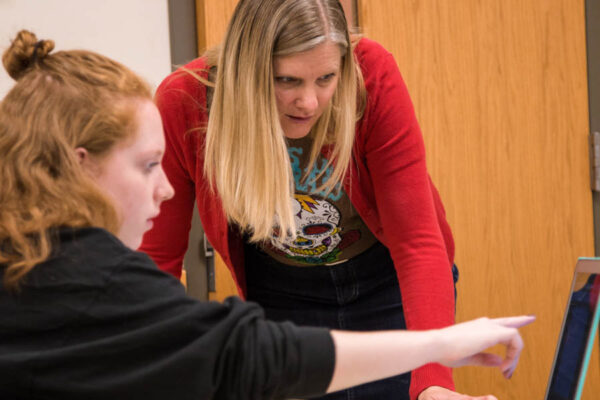Amy Hornby-Uribe working with a student at a desk
