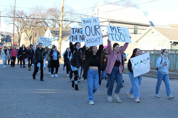 WSU students participating in Take Back the Night, holding signs while walking