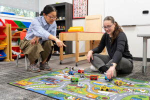 Counselor working with a young patient in a classroom setting.