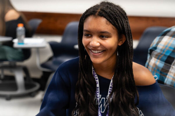 WSU student in a classroom and smiling.