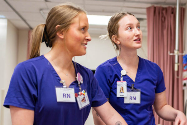 Female Nursing students wearing scrubs during a simulation lab at Winona State.