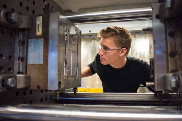 A male student at WSU examines a piece of lab equipment.