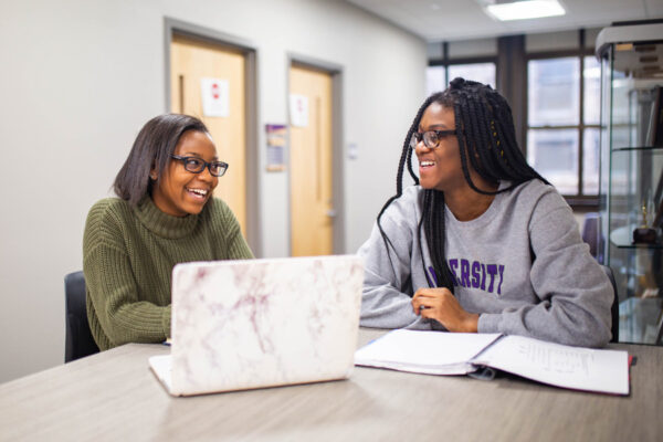 Two WSU students chat while studying in the Business Engagement Center.