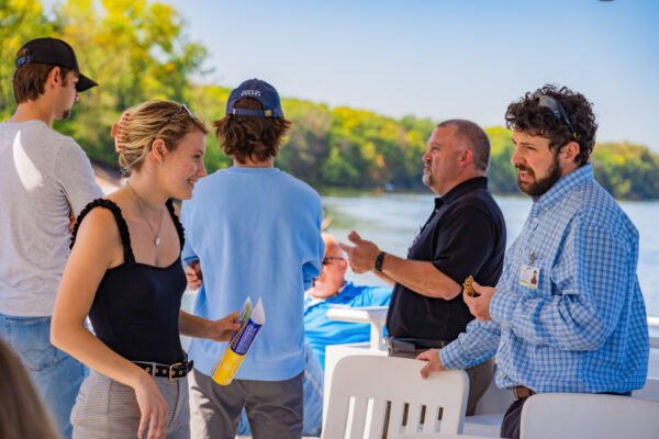 A group of people chat while onboard the Cal Fremling boat.