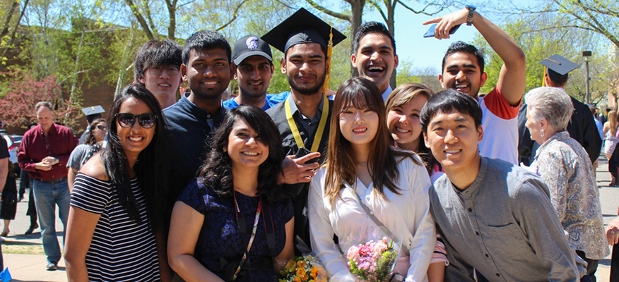 Friends pose for a picture with graduate after the commencement ceremony.