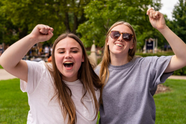 Two female students cheer happily