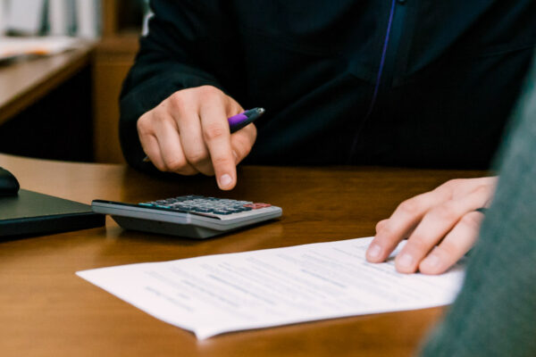 A WSU Financial Aid advisor uses a calculator during a meeting with a student.